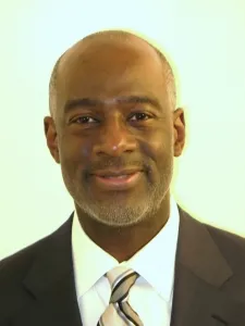 A man in a suit and tie smiling for the camera.